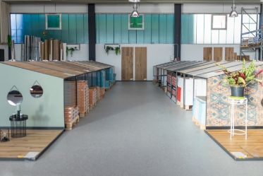 Ausstellungsfläche von Günstigeböden.de mit übersichtlich präsentierten Bodenmustern in einer modernen Halle.